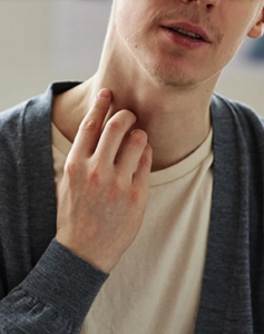 a man itching his neck. from Getty Images